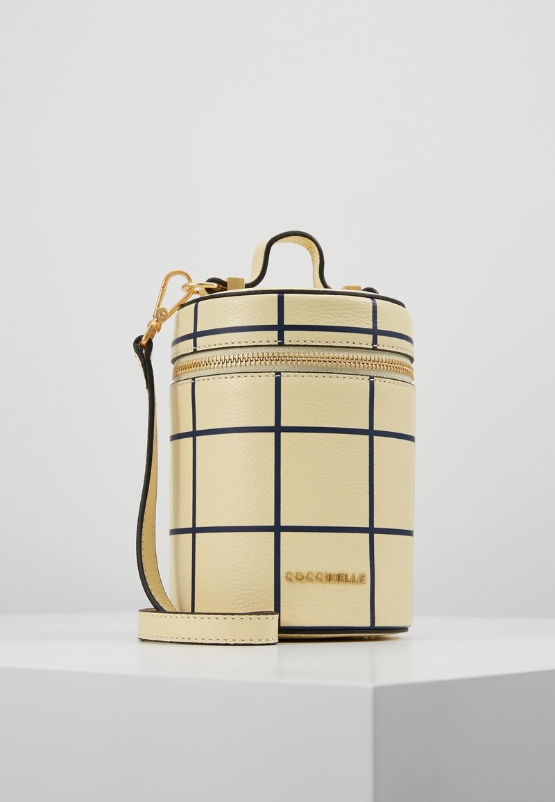Borsa gialla rotonda in pelle testurizzata, con un motivo a griglia con linee navy, una cerniera dorata e una tracolla removibile.