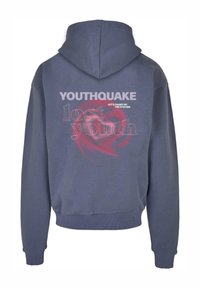 Pelēka kokvilnas kapuce ar priekšējo kabatu, ar lielu, krāsainu grafiku, kas aicina "YOUTHQUAKE" un "LET'S SHAKE UP THE SYSTEM" uz muguras.