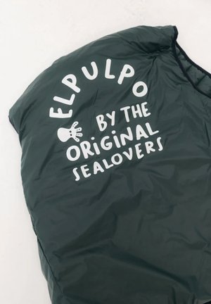 Chaleco acolchado verde con textura brillante, con texto en blanco llamativo: "EL PULPO BY THE ORIGINAL SEALOVERS" y un gráfico de una huella de mano.