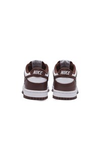 Smeđe i bijele Nike tenisice s glatkom kožom i mrežastim teksturama, podstavljenim ovratnicima i gumenenom potplatom s smeškolikim detaljima.