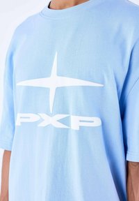 Lichtblauw katoenen T-shirt met korte mouwen, voorzien van een groot wit logo en stergrafiek op de voorkant. Glad van textuur.