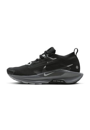 Czarno-szary but biegowy Nike trail z cholewką GORE-TEX, sznurowaniem i teksturowaną podeszwą, widok z boku na białym tle.