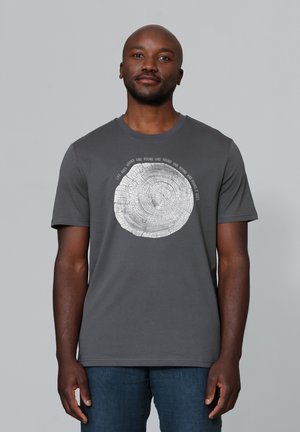 Grijze katoenen t-shirt met een cirkelvormige houtjaargraphic in het wit, omgeven door tekst. Korte mouwen, ronde hals, normale pasvorm.