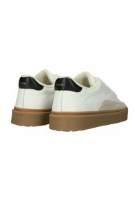 Biele kožené tenisky s béžovými semišovými akcentmi a čiernou pätou. S hnedou gumovou podrážkou a vyrazeným logom značky na zadnej strane.