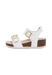 White wedge sandals with two adjustable straps, gold hardware accents, and a textured cork footbed. Features a serrated rubber outsole.