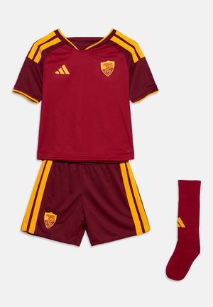 Tenue de football grenat et jaune avec un maillot à manches courtes, un short et une chaussette, avec logos d'équipe et marques Adidas.