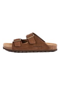 Sandales en suede marron avec deux sangles réglables, boucles métalliques, un semelle en liège et une semelle extérieure en caoutchouc texturé pour une meilleure adhérence.