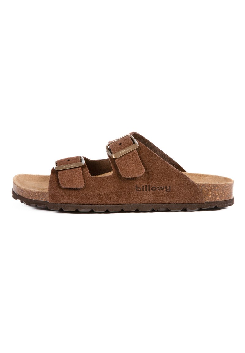 Sandales en suede marron avec deux sangles réglables, boucles métalliques, un semelle en liège et une semelle extérieure en caoutchouc texturé pour une meilleure adhérence.