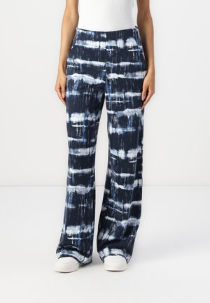 Wide-leg pants in navy with a tie-dye pattern featuring blue and white stripes. Made from lightweight fabric with a smooth texture.