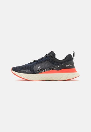 Chaussure de course Nike React Infinity Run noire et bleue avec un swoosh blanc moucheté, une semelle intermédiaire orange vif et une semelle crème, vue de côté.