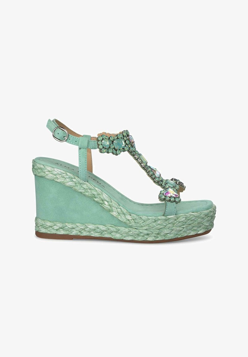 Sandale en wedge turquoise avec une semelle en jute tressé, décorée de gemmes multifacettes sur la bride T, dotée d'une bride de cheville réglable.