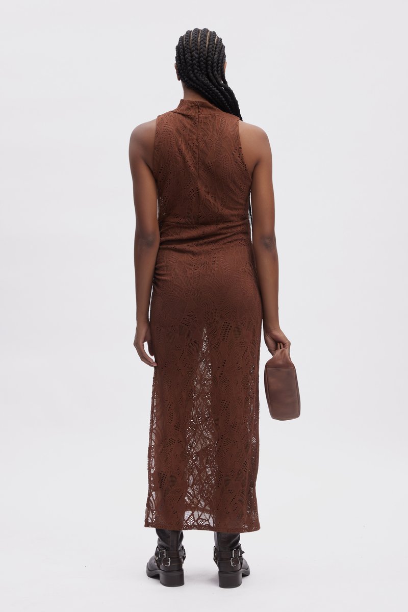 Brązowa koronkowa sukienka maxi z wysokim kołnierzem, dopasowaną górą i otwartym plecami, z misternymi wzorami liści. W połączeniu z czarnymi botkami za kostkę.