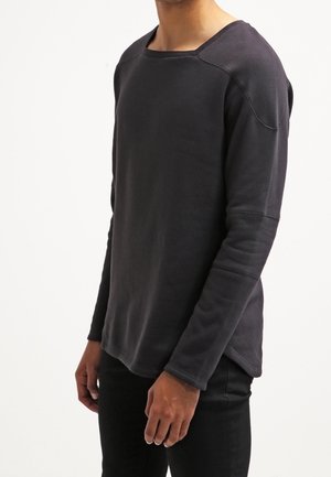 Felpa a maniche lunghe grigia scura con vestibilità comoda, scollo rotondo e maniche raglan. Tessuto morbido con una consistenza liscia e cuciture minime.