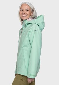 Helle mintgrüne wasserdichte Jacke mit Kapuze, frontalem Reißverschluss und seitlichen Taschen. Sie hat eine glatte Textur und subtile Markenkennzeichnung am Ärmel.