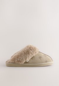 Chausson beige avec une bride en fausse fourrure pelucheuse et un corps en daim arborant un motif discret d'imprimé animalier. Semelle douce et coussinée.