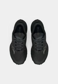 Pár černých běžeckých bot Saucony se šňůrkami, z pohledu shora na světlém pozadí.