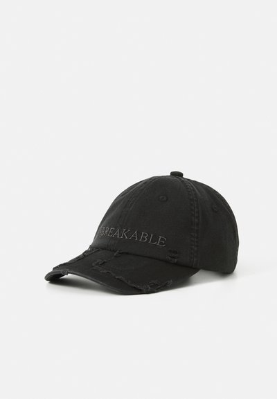 Zwarte versleten baseballpet met het woord "UNBREAKABLE" geborduurd op de voorkant, weergegeven tegen een effen witte achtergrond.