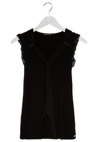 Svart ärmlös topp med spetsdetaljer, knutdetalj vid halsringningen, mjuk väv och en subtil logotyp vid fållen. Hänger från en vit galge.