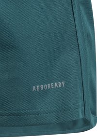 Teal-värinen suorituskykykangas, jossa on teksturoitu pinta, ja siinä on näkyvä "AEROREADY"-logo vaaleanharmaana, reunat ovat huolitellut ja kangas siirtää kosteutta.