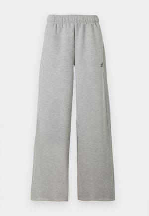 Pantalon de survêtement gris clair à jambes larges, avec taille élastique et petit logo noir Adidas sur la cuisse droite.