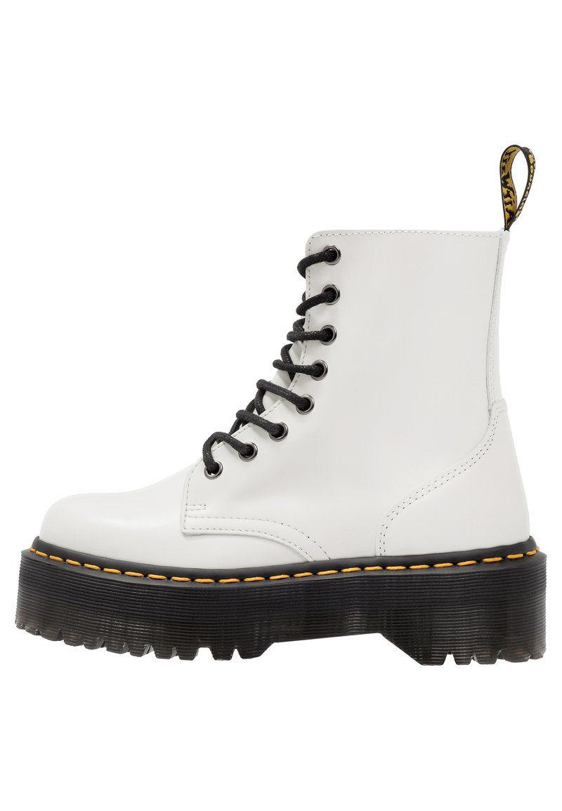 Botas de combate de cuero blanco con cordones negros, suela gruesa de goma negra y detalle de costura amarilla a lo largo del borde de la suela.