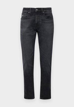 Juodi džinsai su tiesiu kirpimu, su penkių kišenių dizainu ir užtrauktuku. Subtilūs blukimo ir siuvimo detalės ant kišenių.