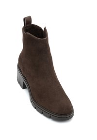 Brązowy zamszowy botek za kostkę z zaokrąglonym noskiem, niskim obcasem typu klockowego i boczną pętelką do zakładania. Charakteryzuje się fakturowanym wykończeniem i trwałą gumową podeszwą.