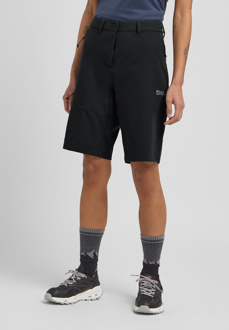 Schwarze Outdoor-Shorts mit figurbetontem Design, aus einem strapazierfähigen Material gefertigt. Verfügt über einen Frontknopfverschluss und Seitentaschen. Getragen mit grauen Socken im Bergmuster.