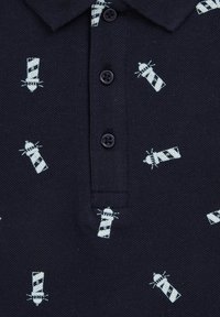 Sötétkék polo póló gallérral, világoskék világítótorony mintával. Három gombos gombolás sötét gombokkal és texturált anyaggal.