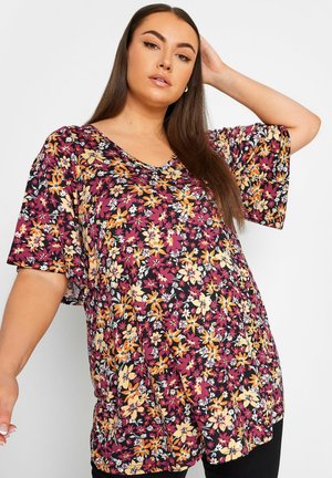 Top floreale di un profondo viola con scollatura a V, maniche corte a palloncino, decorato con fiori arancioni, gialli e bianchi su uno sfondo nero.