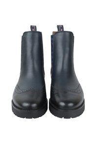 Czarne skórzane botki za kostkę z detalami w stylu brogue, masywnymi podeszwami i pętelkami z różowym przeszyciem na białym tle.