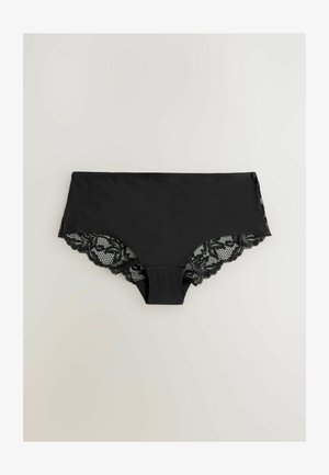 Culotte en dentelle noire avec un panneau avant lisse et des bords en dentelle festonnés sur les côtés et à l'arrière, mettant en valeur des motifs détaillés.