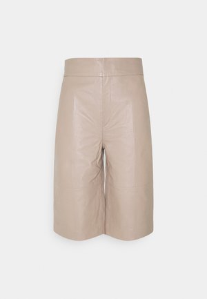 Beige hooggetailleerde leren shorts tot op de knie met voornaaddetails en een aansluitende tailleband op een witte achtergrond.