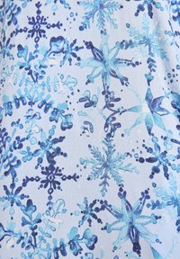 Tessuto di un azzurro chiaro con un motivo di vari fiocchi di neve in tonalità di blu, con dettagli in blu scuro e acqua, creando un aspetto texture.