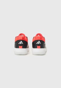 Chaussures de sport noires et rouges avec une tige en mesh, semelle blanche et marque Cloudfoam. Présente un logo distinctif à trois bandes au talon.