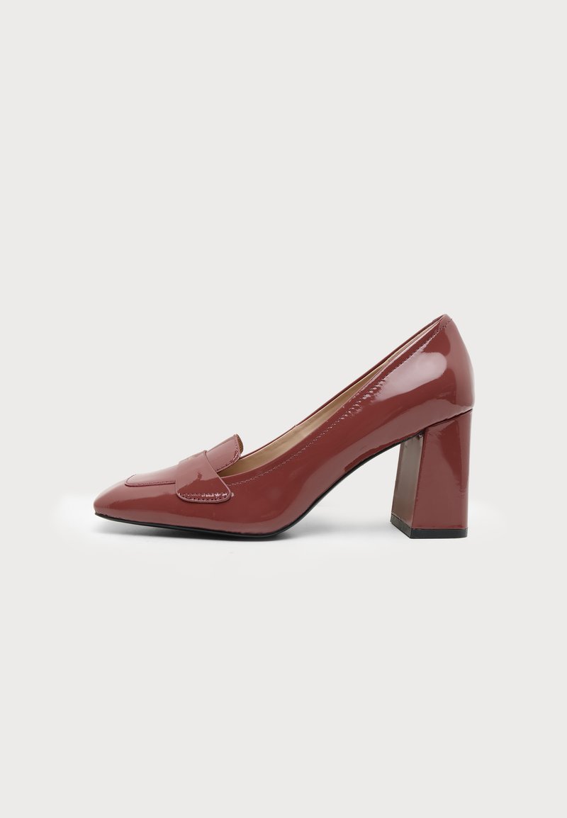 Chaussure à talon bloc pour femme rouge foncé brillante, avec bout arrondi et bride style mocassin sur le dessus, présentée sur un fond blanc uni.
