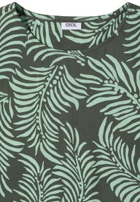 T-shirt vert à col rond avec un motif abstrait de feuilles vert clair et une étiquette blanche mentionnant "CECIL" au niveau du col.