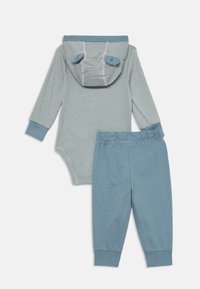 Gestreiftes langärmeliges Bodysuit mit Kapuze und Ohrakzenten, kombiniert mit einfarbigen blauen Hosen. Hergestellt aus weichem Stoff, entworfen für Komfort und Bewegungsfreiheit.