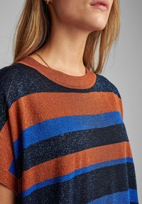 Randig t-shirt med horisontella ränder i orange, blått och svart, med en texturerad yta och en rund halsringning.