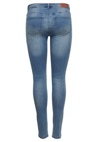 Jeans ajustados de denim azul claro con una textura suave, que cuentan con una costura en el yugo, dos bolsillos traseros y una etiqueta de piel de la marca en la cintura.