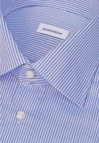 Chemise habillée rayée bleue et blanche avec un col spread et des boutons blancs, étiquetée "seidensticker" à l'intérieur du col.
