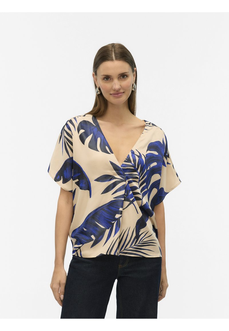 Lichtbeige blouse met korte mouwen en een blauw tropisch bladerenpatroon, V-halsontwerp, zachte stof en geplooid detail bij de taille.