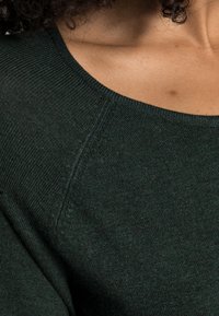 Dunkelgrüner Pullover mit geripptem Rundhalsausschnitt und strukturiertem Strickstoff. Verfügt über einen eingesetzten Schulterdesign und eine glatte, weiche Oberfläche.