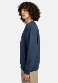 Navy blue sweatshirt with crew neckline, ribbed cuffs, and a relaxed fit; made from soft cotton blend fabric.