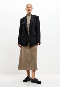 Černé upravené sako, béžový rolák, hnědá semišová midi sukně a černé mokasíny. Sako má strukturované ramena a dvě kapsy.