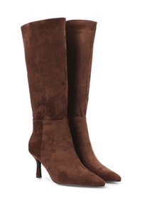 Botas altas hasta la rodilla de ante marrón, con puntera puntiaguda, tacón alto y delgado, y textura suave, con un diseño elegante y ajustado a lo largo de la pierna.