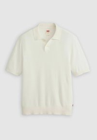 Vit kortärmad polo tröja tillverkad av strukturerad stickad tyg, med krage, tre knappar vid halsen och ribbat avslut.