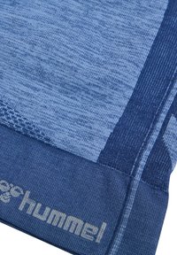 Blå idrottstyg med olika texturer och nyanser, med en framträdande logotyp. Texturen inkluderar ribbade och släta sektioner.