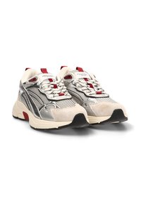 Zapatillas deportivas plateadas y beige con parte superior de malla, cuello acolchado, acentos rojos, detalles texturizados en gris, suela de goma y un intrincado sistema de cordones.