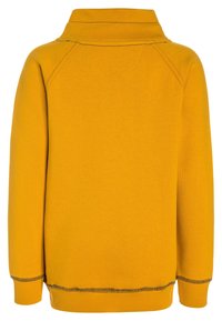 Felpa gialla con colletto alto, polsini e orlo a coste. Il tessuto presenta una finitura testurizzata con dettagli di cucitura neri in contrasto.